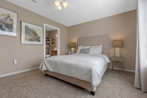 A bedroom with a large bed and a ceiling fan.