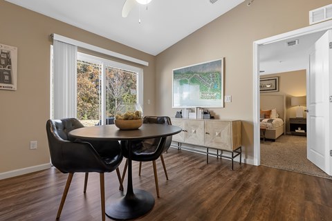 A dining room with a table and chairs.