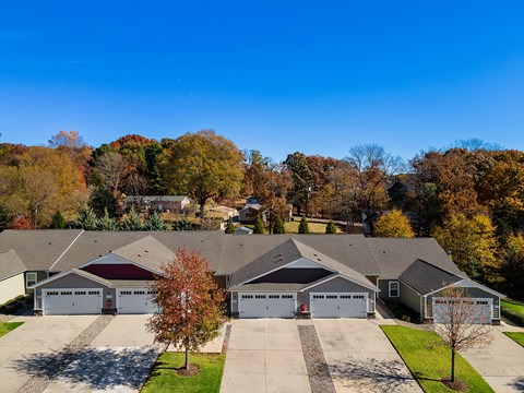 A row of houses with garages and trees in autumn colors.