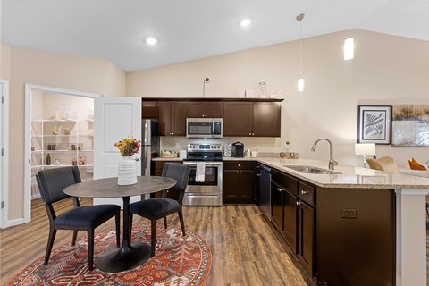 A kitchen with a table and chairs in the middle of the room.
