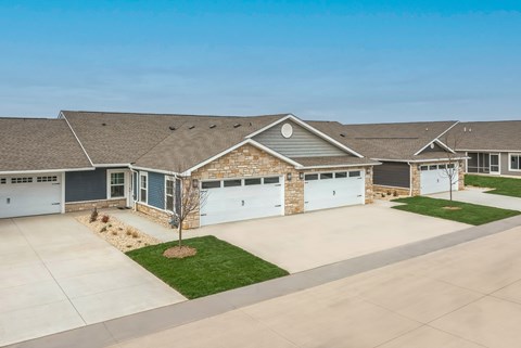 A house with a grey roof and a white garage door.