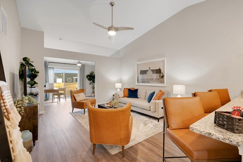 A living room with a white couch and orange chairs.