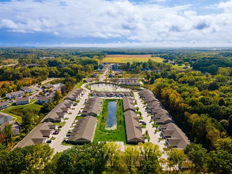 A bird's eye view of a residential area with houses and a swimming pool.