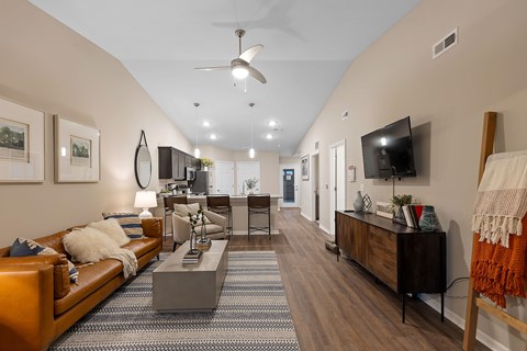 A living room with a brown couch and a grey coffee table.