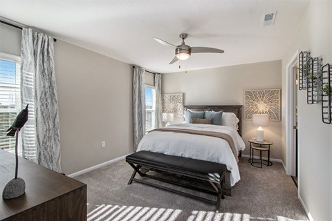 A bedroom with a large bed and a ceiling fan.