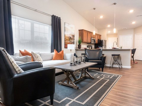 A modern living room with a black leather couch and a coffee table.