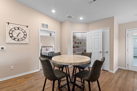 A dining room with a round table and chairs.