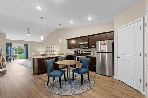 A modern kitchen with a table and chairs in the middle.