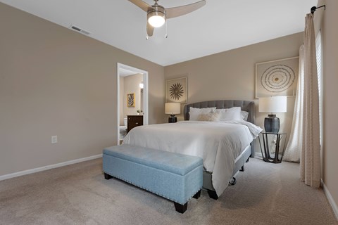 A bedroom with a bed and a ceiling fan.