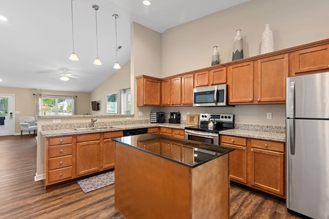 A kitchen with wooden cabinets and a black island.