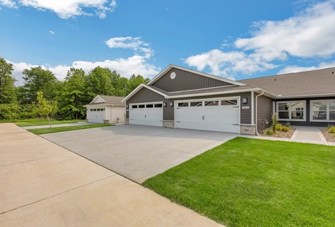 A large house with a grey roof and a white garage door.