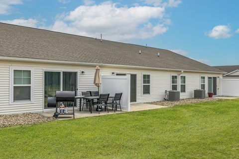 A house with a patio and a table set up outside.