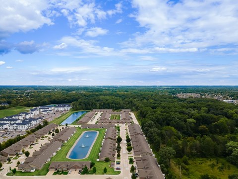 A bird's eye view of a residential area with a swimming pool and apartment buildings.