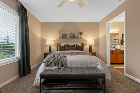 A bedroom with a large bed and a ceiling fan.