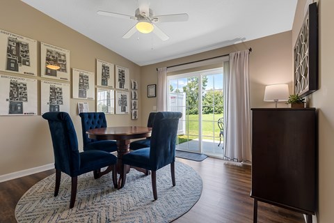 A dining room with a table and chairs.