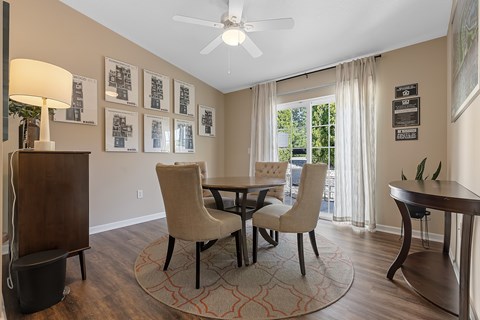 A dining room with a table and chairs.