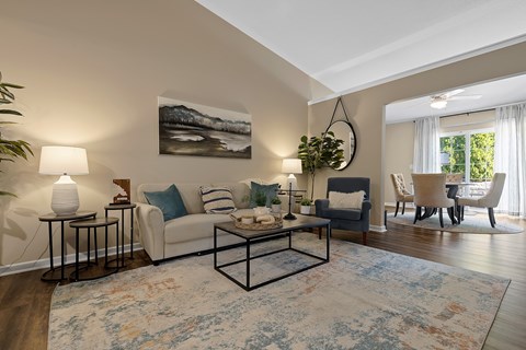 A living room with a white couch, a coffee table, and a painting on the wall.
