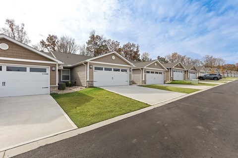 A row of houses with garages and driveways.