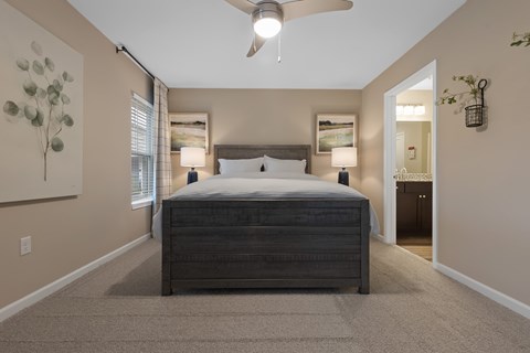A bedroom with a large bed and a ceiling fan.