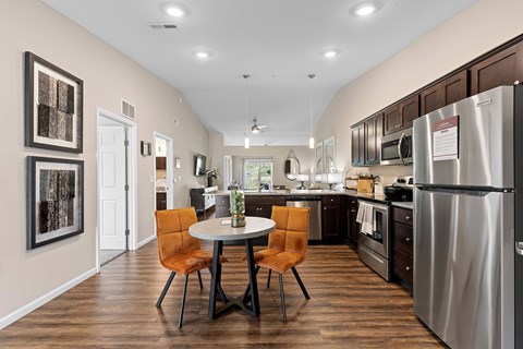 A kitchen with a table and chairs in the middle of the room.