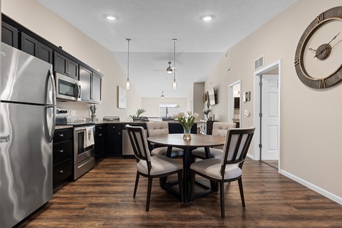 A modern kitchen with a dining table set for two.