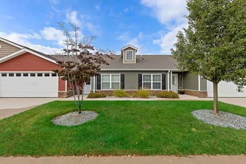 A house with a red garage door and a grey roof.