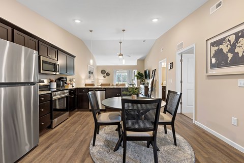 A kitchen with a table and chairs in the middle of the room.