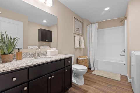 A bathroom with a white toilet and a white bathtub.