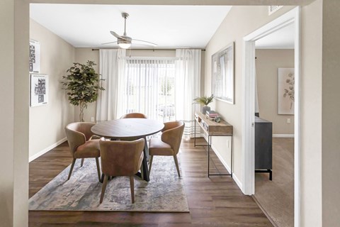 A dining room with a round table and chairs.