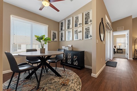 A dining room with a round table and chairs.