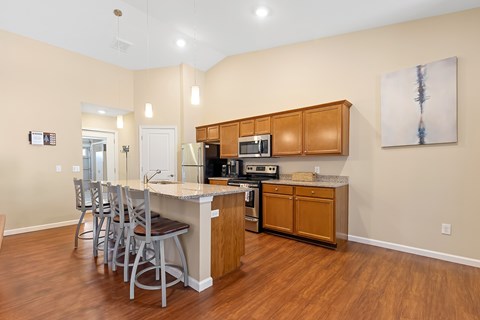 A kitchen with wooden cabinets and a white island.
