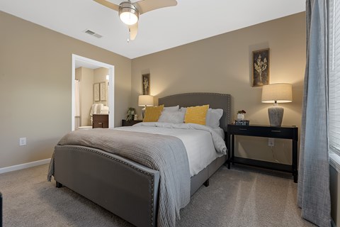 A bedroom with a large bed and a ceiling fan.