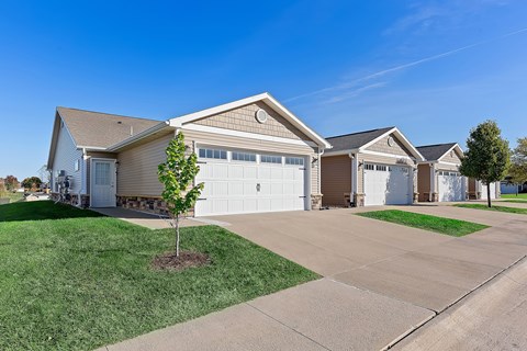A row of houses with a tree in front of the first one.