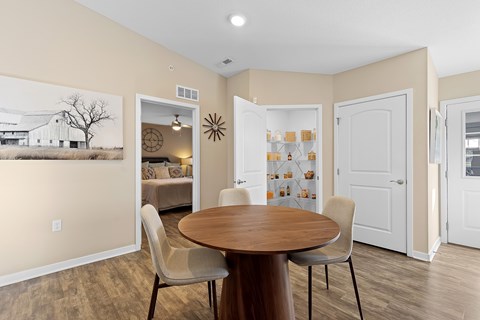 A dining room with a wooden table and chairs.