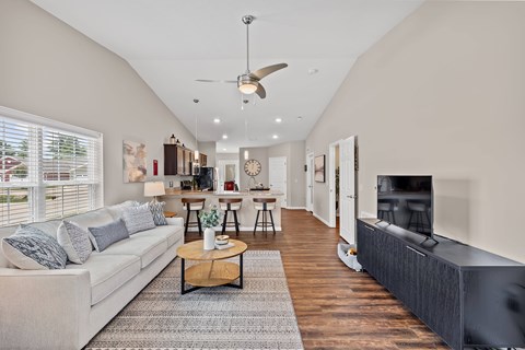 A living room with a white couch and a wooden coffee table.