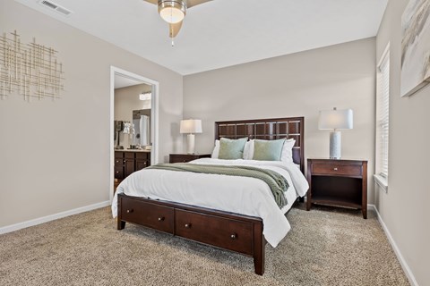 A bedroom with a large bed and a chandelier.