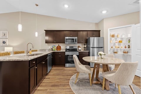 A modern kitchen with dark brown cabinets and a white island.