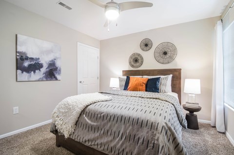 A bedroom with a large bed and a ceiling fan.