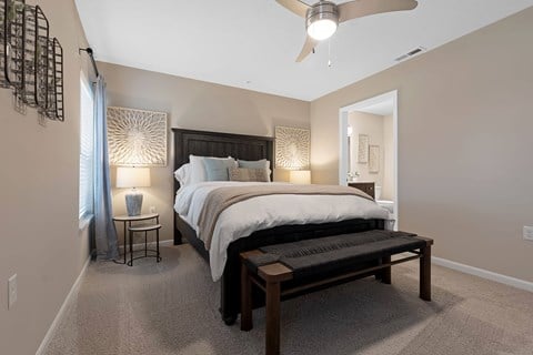 A bedroom with a large bed and a ceiling fan.