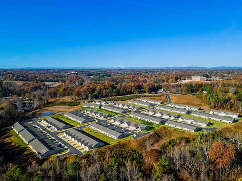 A bird's eye view of a residential area with houses surrounded by trees.