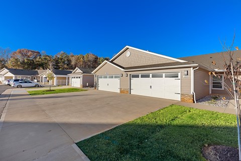 A house with a garage and a driveway in front of it.