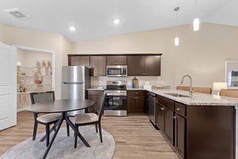 A kitchen with brown cabinets and a table with four chairs.