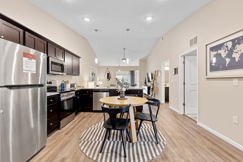 A kitchen with a table and chairs in the middle of the room.