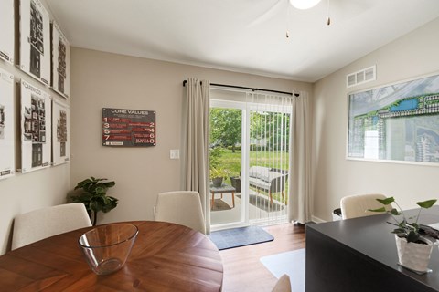 A dining room with a wooden table and chairs.