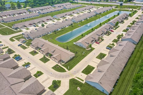 A bird's eye view of a residential neighborhood with houses and a swimming pool.