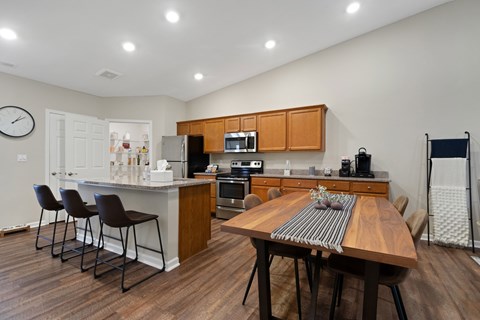 A kitchen with a table and chairs in the middle of the room.
