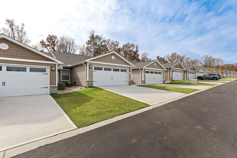 A row of houses with garages and driveways.