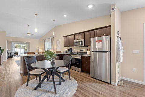 A modern kitchen with a table and chairs in the middle of the room.