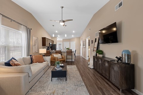 A living room with a couch, coffee table, and a television.