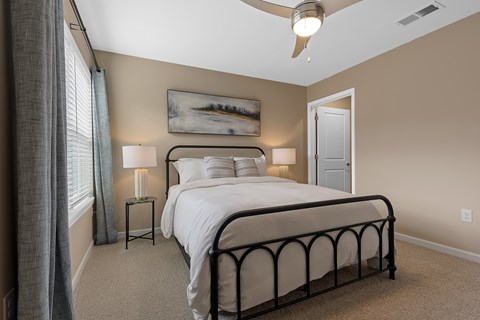 A bedroom with a large bed and a ceiling fan.